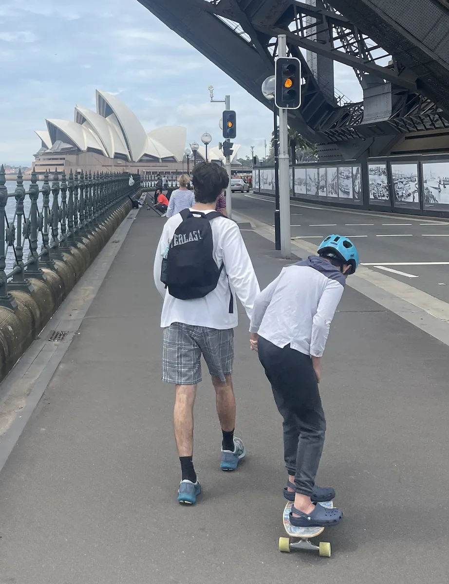 Support worker with a young person skateboarding near Sydney Harbour